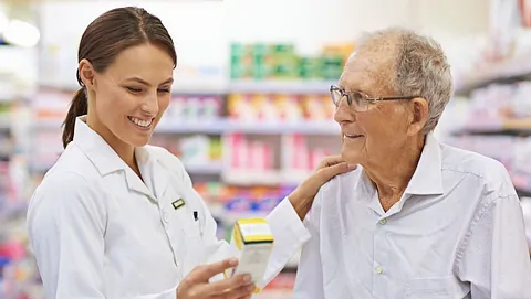 farmacéutica atendiendo a cliente anciano